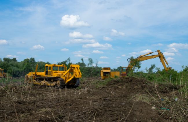 Bulldozer and excavator clearing and levelling rural land, part of professional site preparation by Rural Property Services NSW.