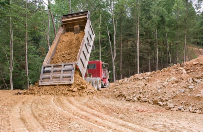 Dump truck tipping soil on a rural property during a haulage job by Rural Property Services NSW