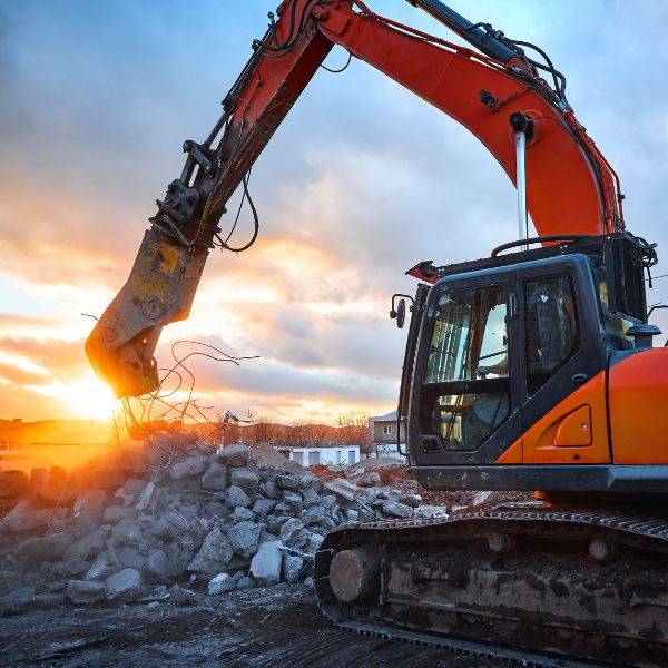 Excavator clearing rubble at a rural demolition site. Safe and professional teardown by Rural Property Services NSW. Excavator clearing rubble at a rural demolition site. Safe and professional teardown by Rural Property Services NSW.
