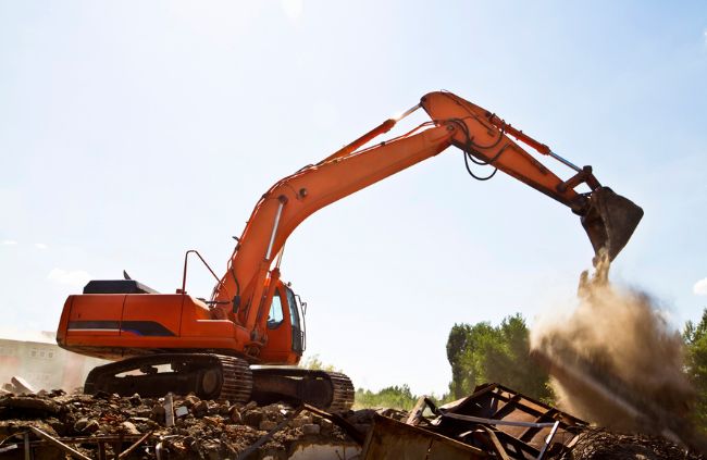 Excavator loading debris at a rural demolition site, showing rubbish removal and land clearing work by Rural Property Services NSW. Excavator loading debris at a rural demolition site, showing rubbish removal and land clearing work by Rural Property Services NSW.