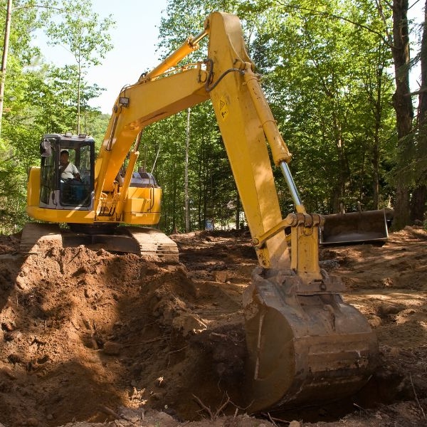 Excavator working on rural earthmoving project in a forested area by Rural Property Services NSW