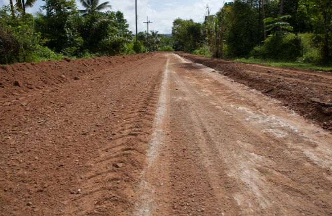 Freshly graded rural dirt road through bushland, built during a private road construction project.