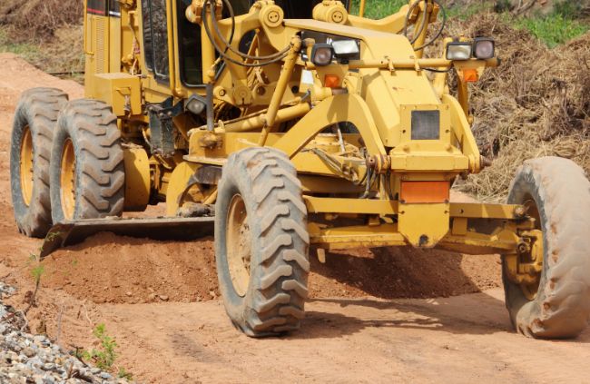 Grader levelling a dirt driveway on a rural property, part of professional driveway construction by Rural Property Services NSW.