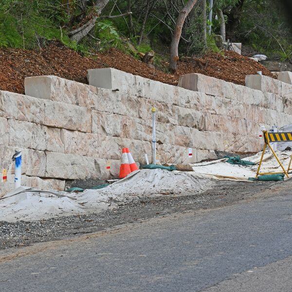 Large sandstone block retaining wall built beside a rural road by Rural Property Services NSW. Large sandstone block retaining wall built beside a rural road by Rural Property Services NSW.
