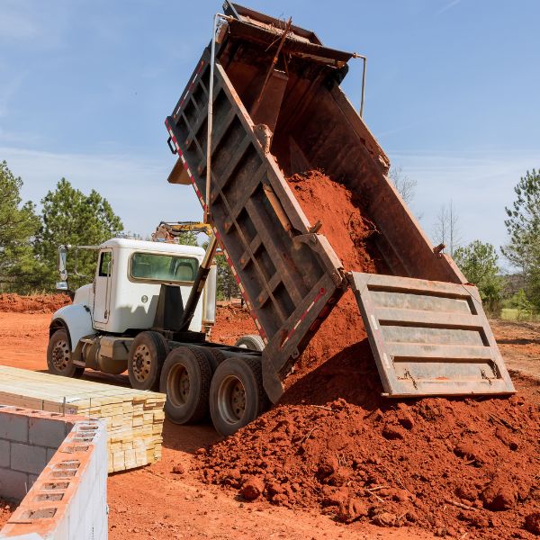 Tipper truck unloading soil at a rural site, part of haulage and material delivery by Rural Property Services NSW