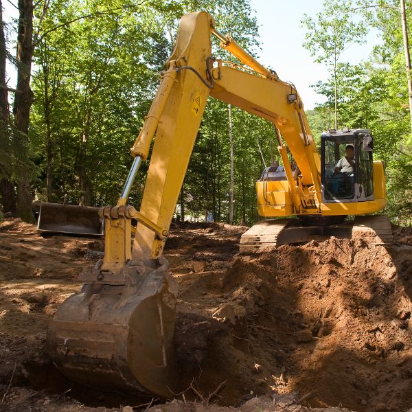 Excavator digging on a rural property during bulk excavation works by Rural Property Services NSW, preparing the site for construction or drainage